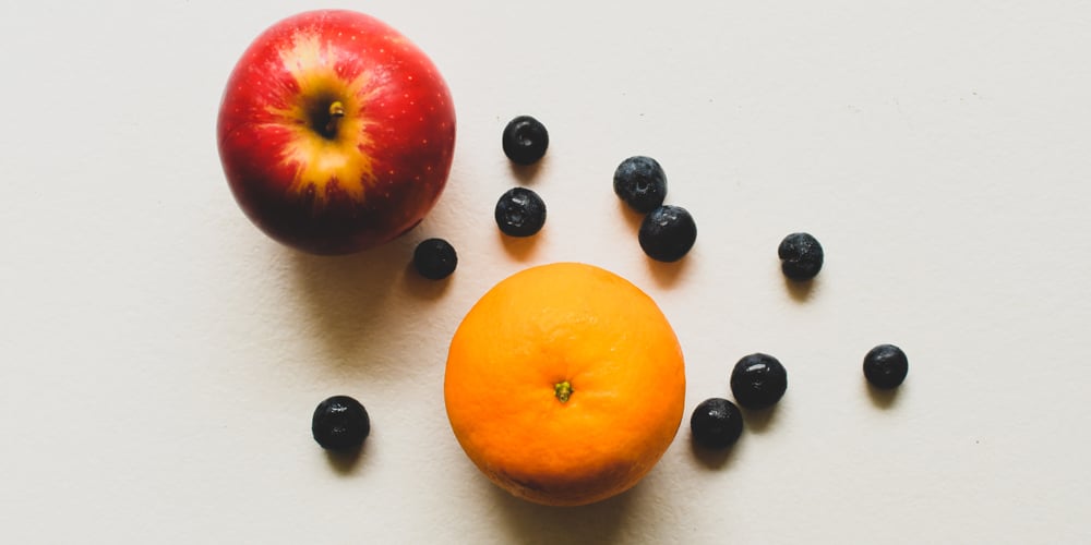 Apple, orange, and blueberries on a table