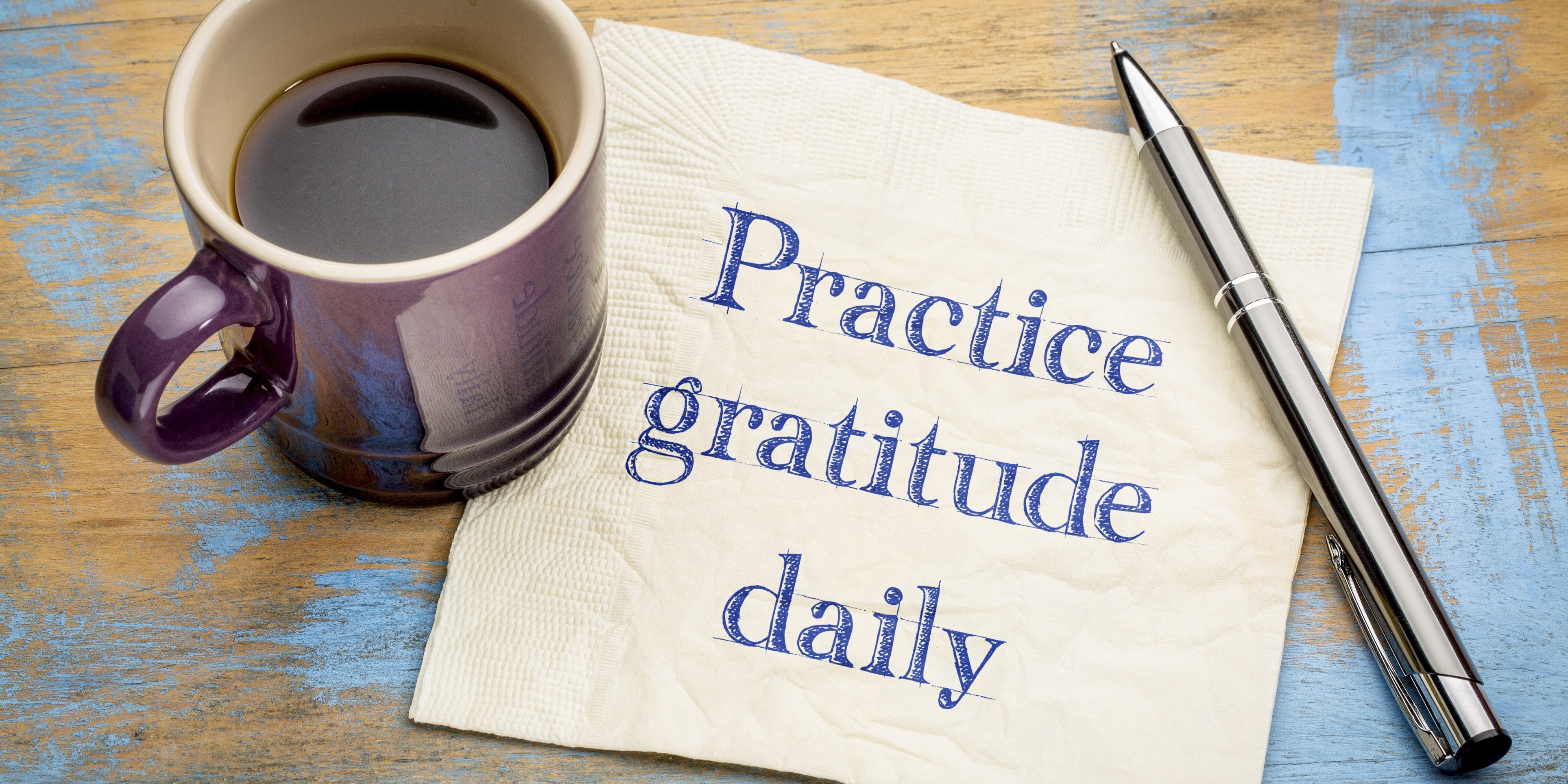 Napkin with “practice gratitude daily” written on it in pen