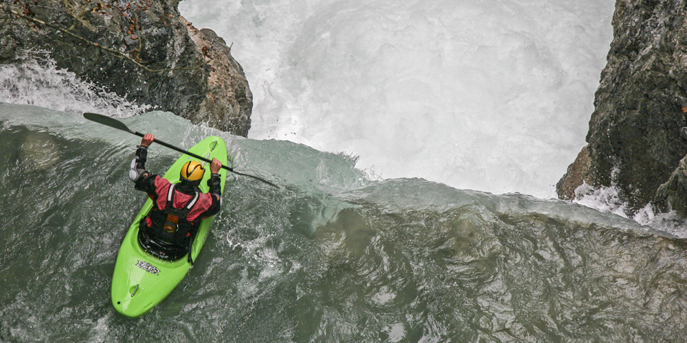 Kayaker approaching steep waterfall