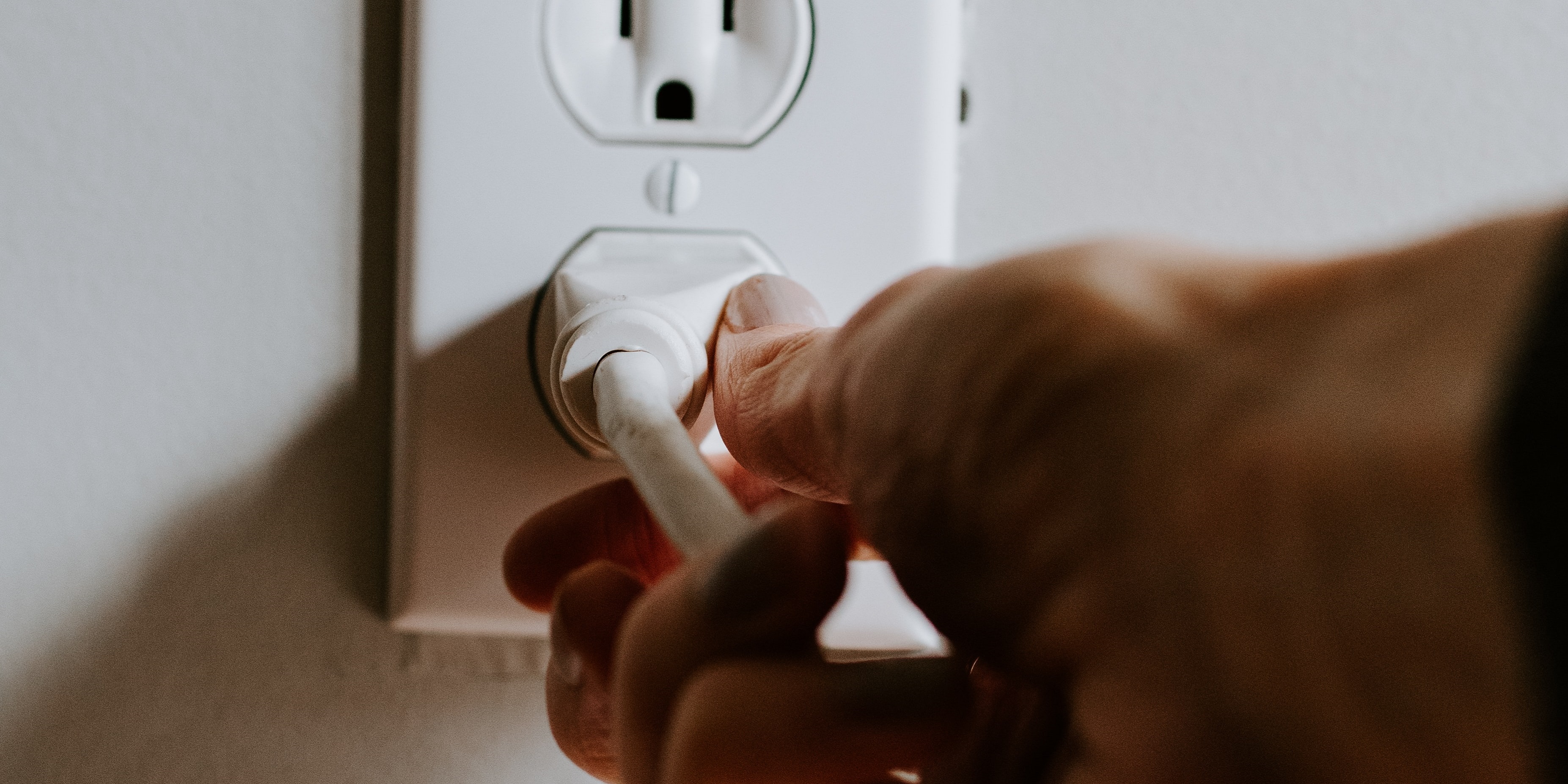 Hand unplugging power cord