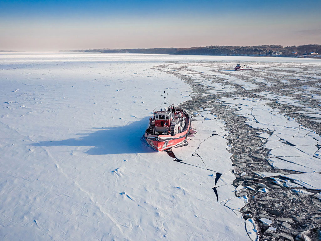 Ship breaking through ice to form a new pathway