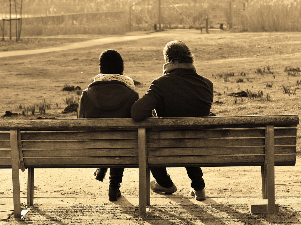 Two people sitting on park bench